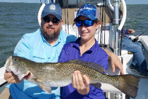 Couple staying in Avon, NC showing off large Gray Trout.