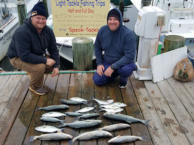 Brothers Nick and Nathan Eaver kneeling behind their day's catch on the Teach's Lair Dock..