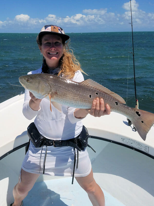 Young angler holds large Red Drum .