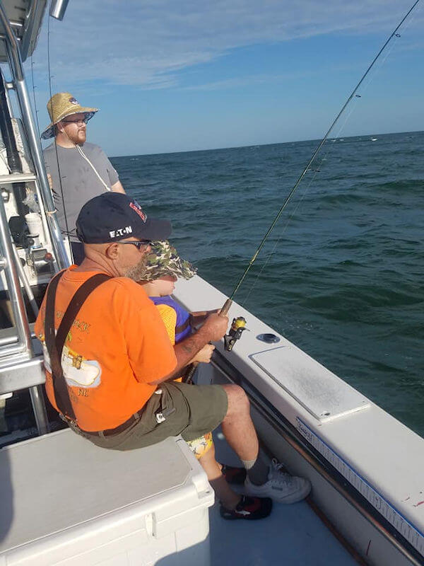 Angler sitting down concentrating on catching a bluefish.