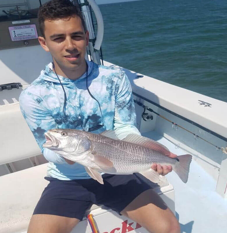 Anglers holds his catch of a red drum.