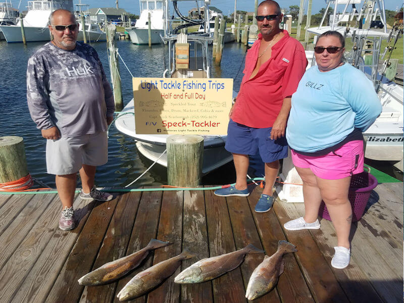 JT, Angelique and Lou standing at the dock behind their charter catch.