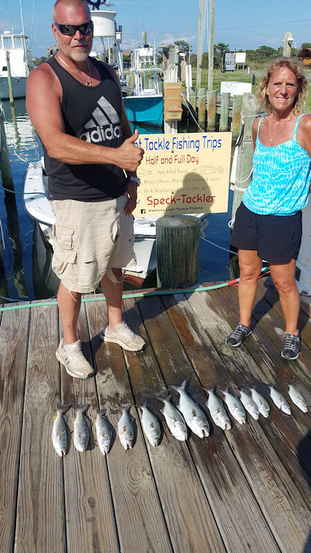 Courtney and John Veneziani standing on the dock at Teach's Lair with their catch of Gray Trout and Bluefish.