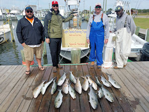 Charter group standing behind their impressive catch at Teach's Lair dock.